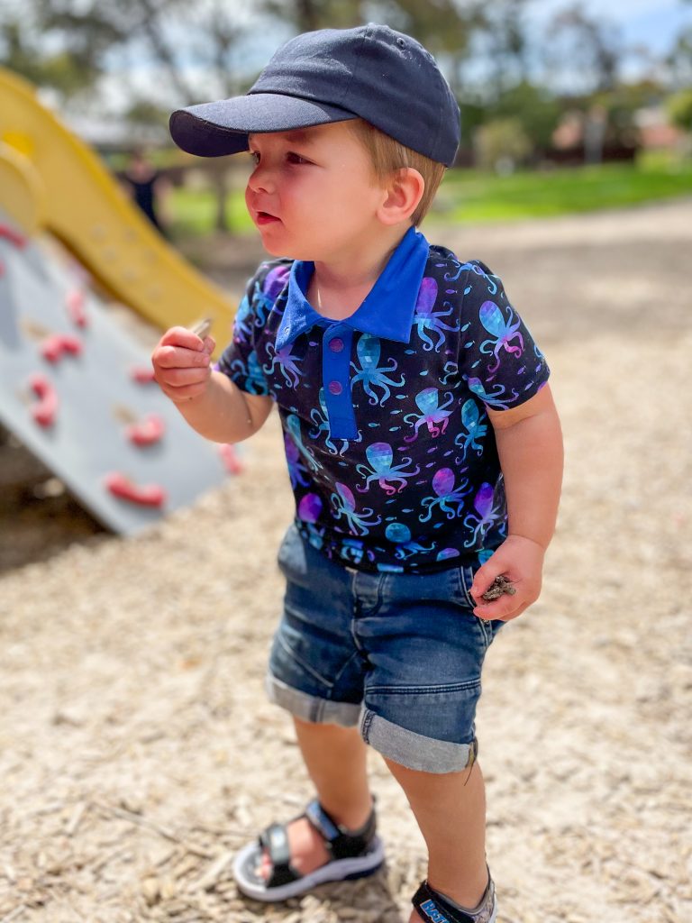 little boy in dark blue polo shirt with octopus print
