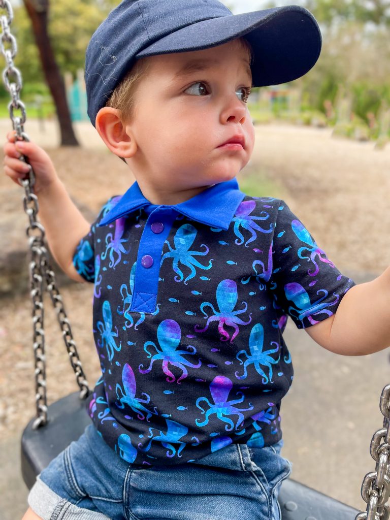 little boy in dark blue polo shirt with octopus print