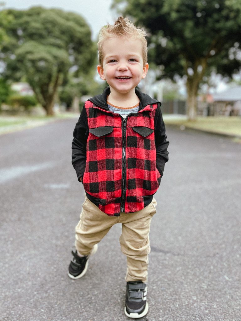 smiling photo of a kid wearing Dutchie jacket with hands in pocket