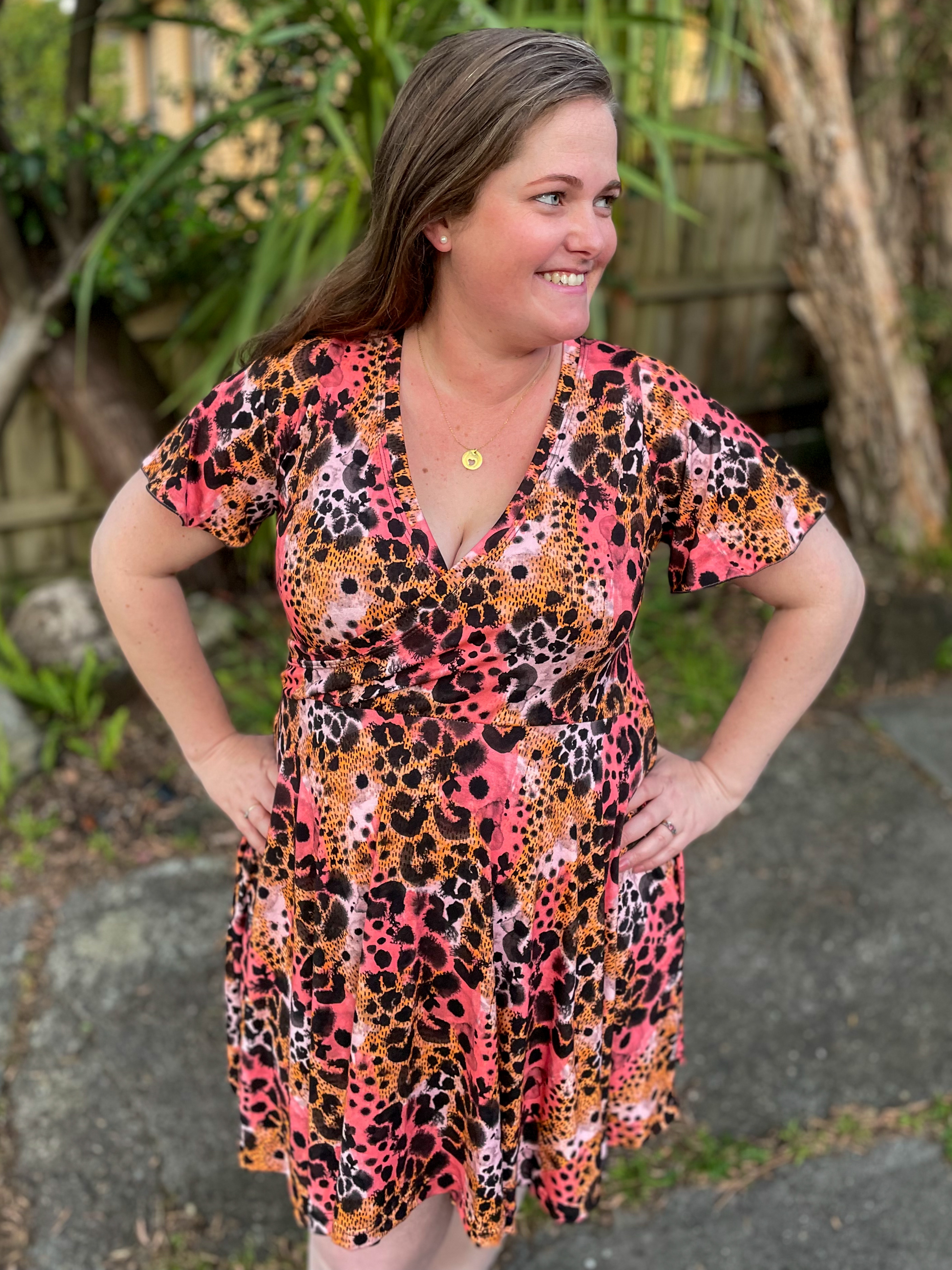 Fashionable woman posing in leopard print dress.
